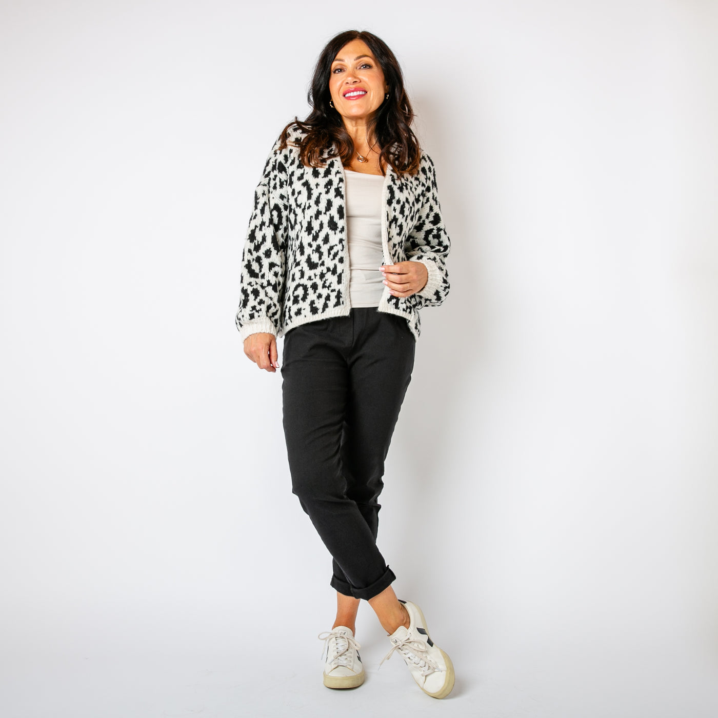 The black Leopard Print Cardigan paired with a cream background 