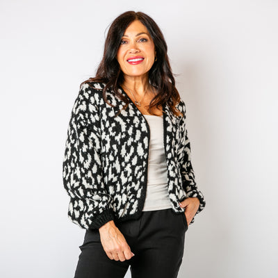 The monochrome Leopard Print Cardigan paired with a black background 