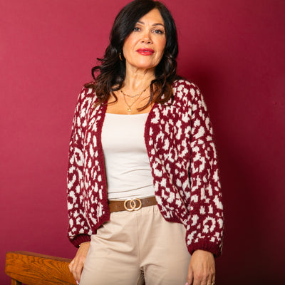 The wine red Leopard Print Cardigan paired with a cream background 