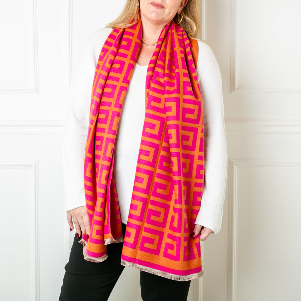 The Libby Pattern Scarf in pink and orange featuring a fun geometric square swirl print pattern