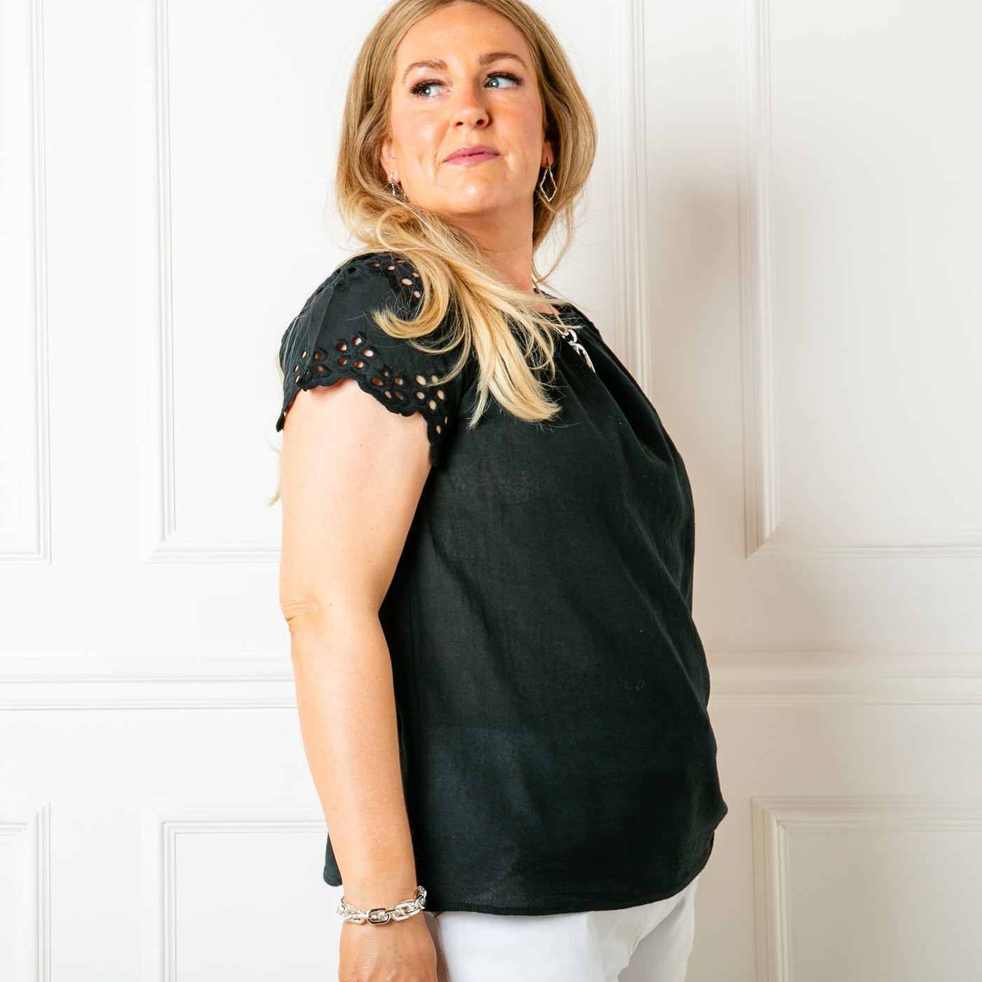 The black Linen Blend Flutter Top with short sleeves that feature beautiful broderie detailaing and can be worn on or off the shoulder