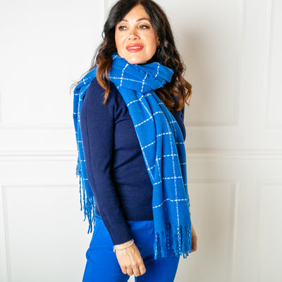 The Maisy Check Scarf in royal blue featuring a chic checkered pattern and tassels on both ends