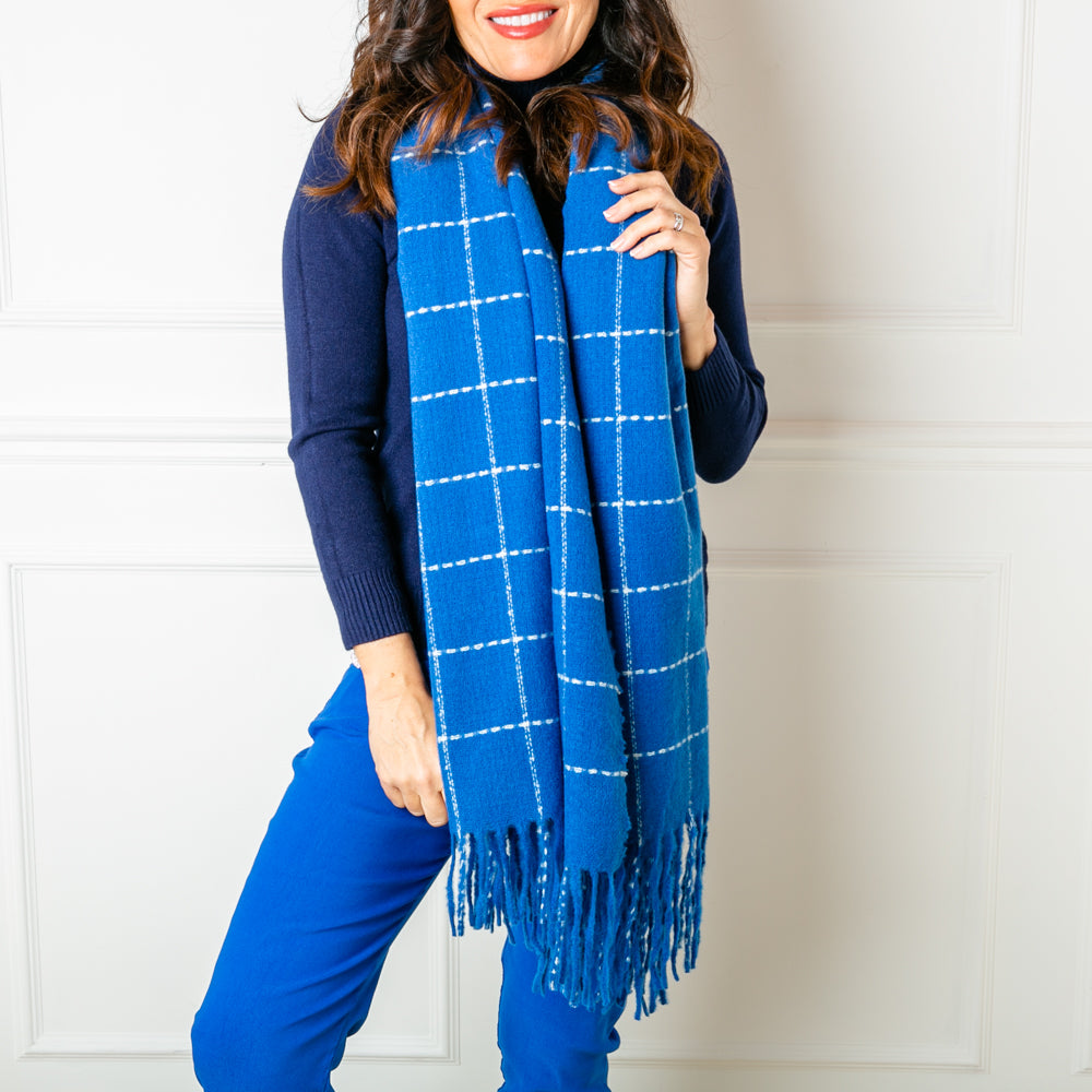 The Maisy Check Scarf in royal blue made from a chunky knit that is 100% polyester 
