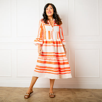 The Neon Folk Dress in cream with vibrant orange aztec patterns across the body and sleeves