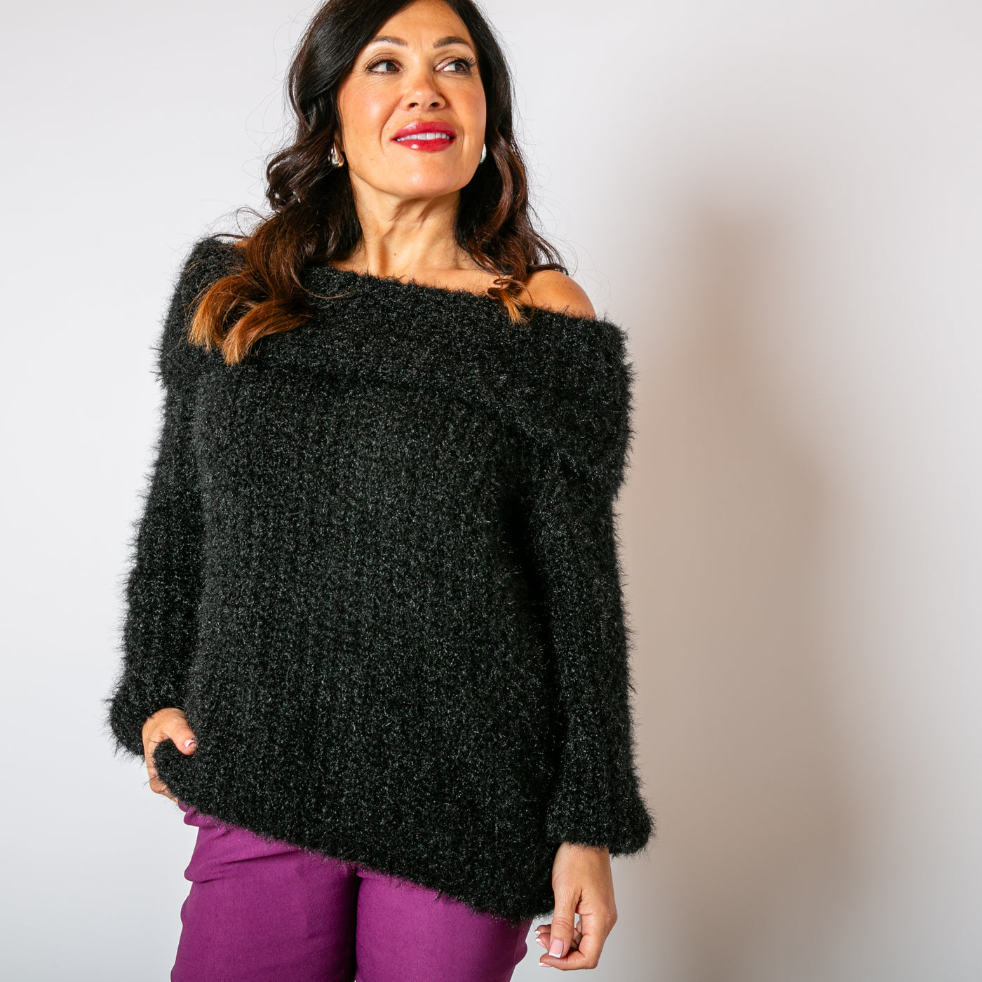 The Off Shoulder Jumper in black made from a chunky knitted blend of nylon and acrylic