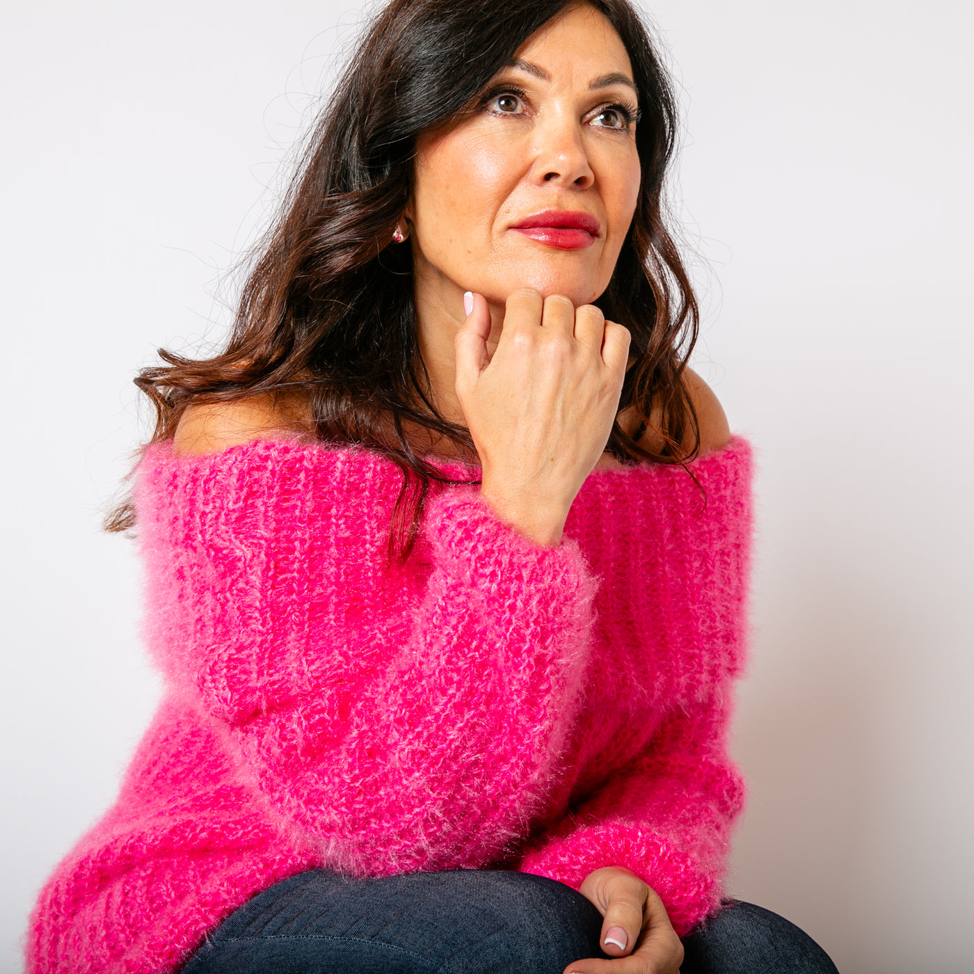 The Off Shoulder Jumper in fuchsia pink made from a chunky knitted blend of nylon and acrylic