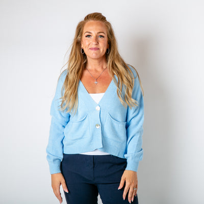 The baby blue Pearl Button Cardigan with pockets on either side of the chest