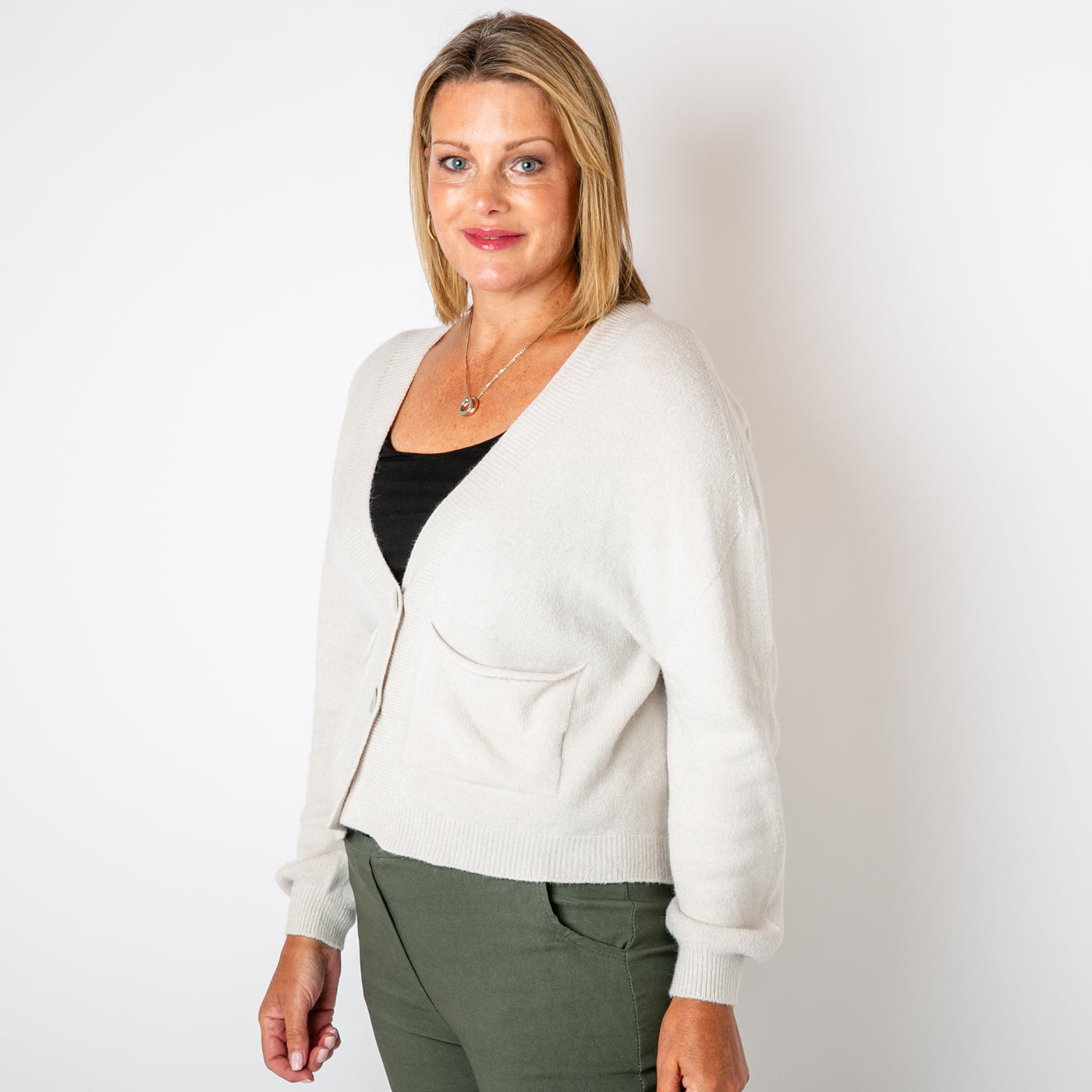 The cream Pearl Button Cardigan with pockets on either side of the chest