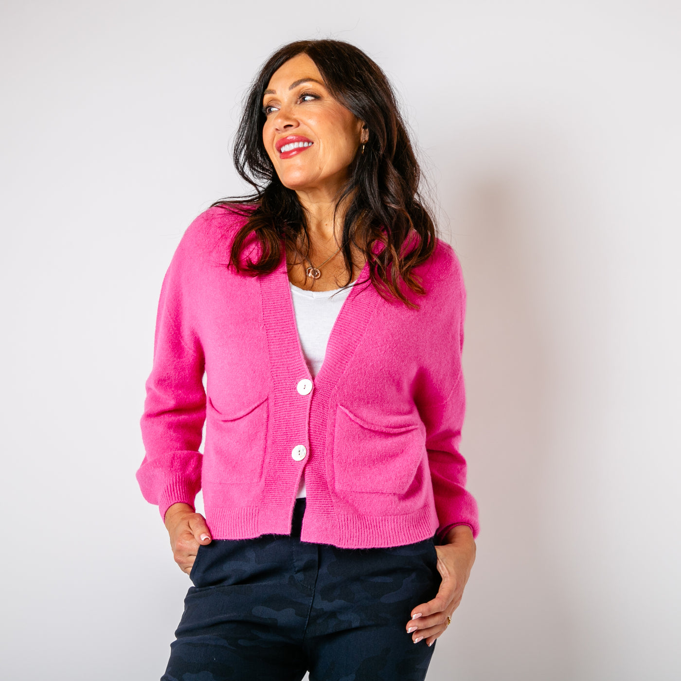 The fuchsia pink Pearl Button Cardigan with pockets on either side of the chest