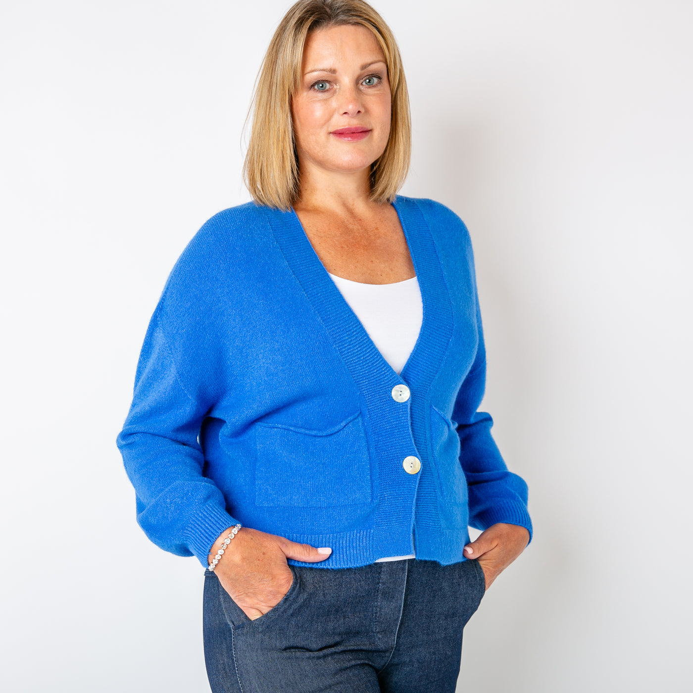 The royal blue Pearl Button Cardigan with pockets on either side of the chest