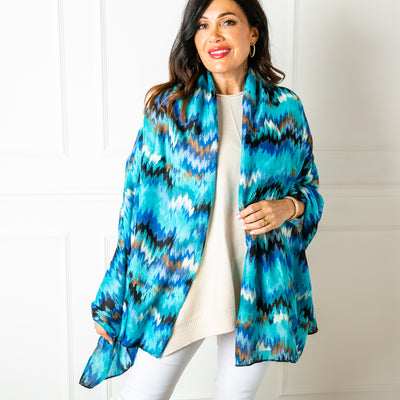 The Phoenix Scarf in royal blue with hints of metallic gold throughout the pattern