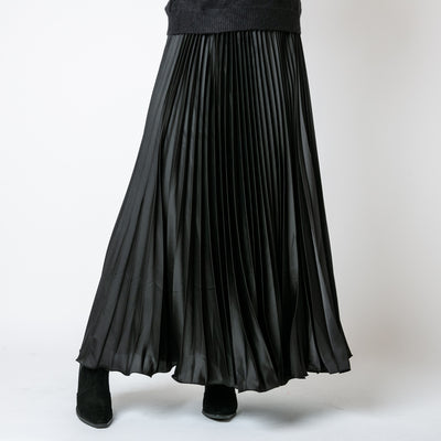 The Pleated Cocktail Skirt in black made from an elegant material with a satin finish