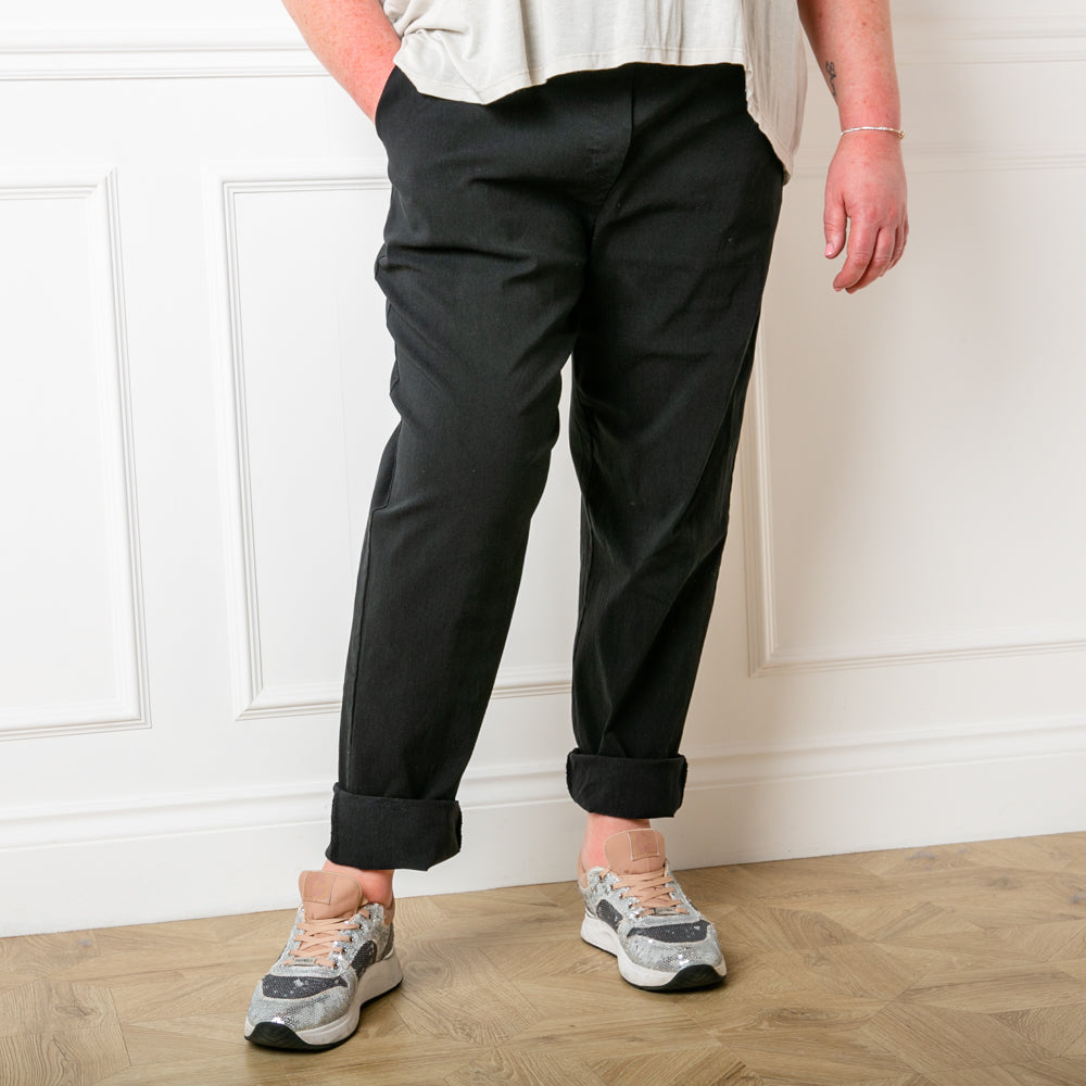 Plus size stretch trousers in black with pockets on either side. The bottom hem can be rolled up to any length 