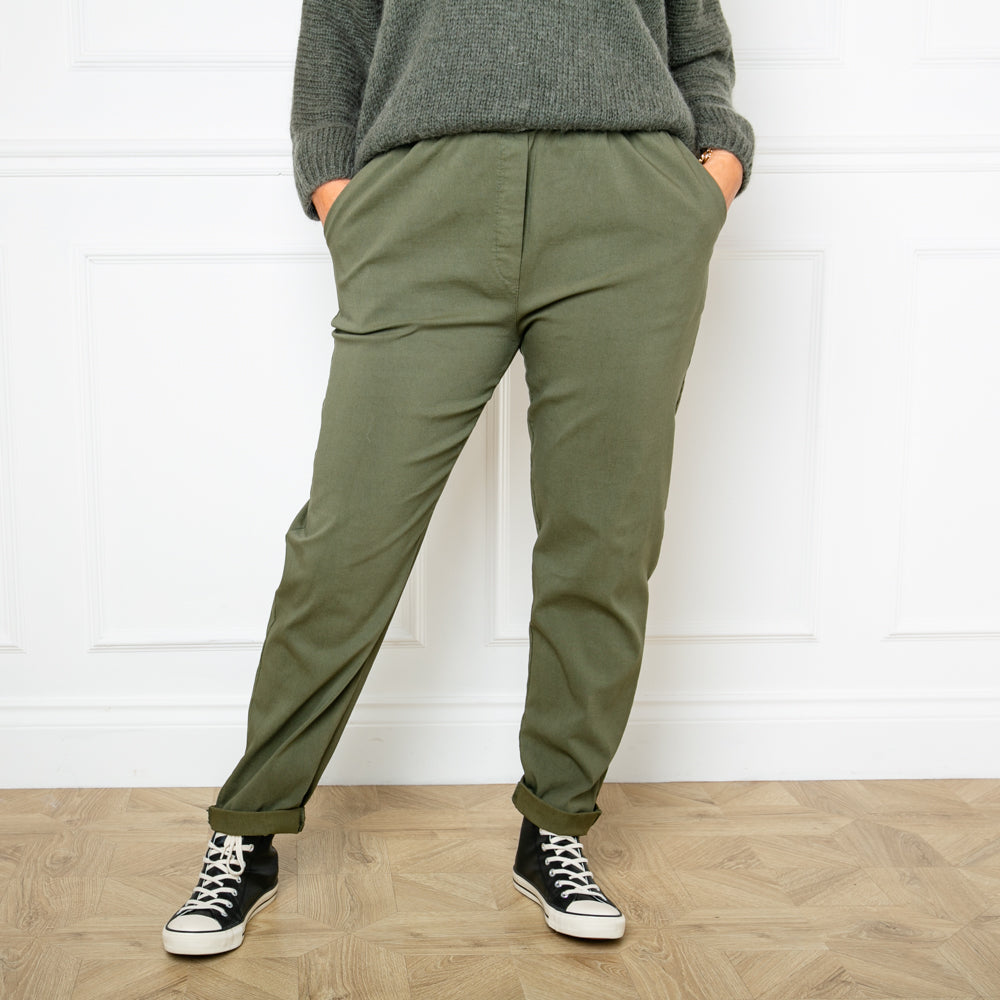 Plus size stretch trousers in khaki green with pockets on either side. The bottom hem can be rolled up to any length