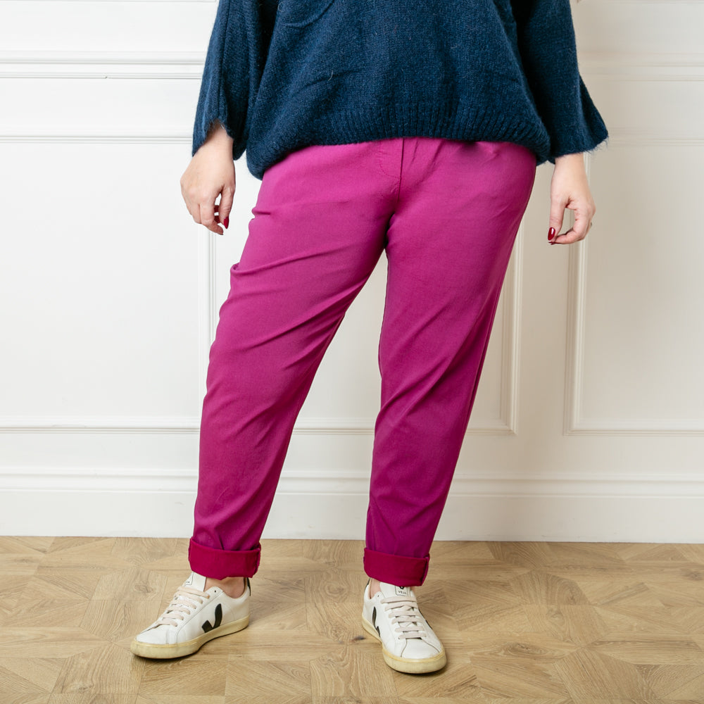 Plus size stretch trousers in plum purple with pockets on either side. The bottom hem can be rolled up to any length