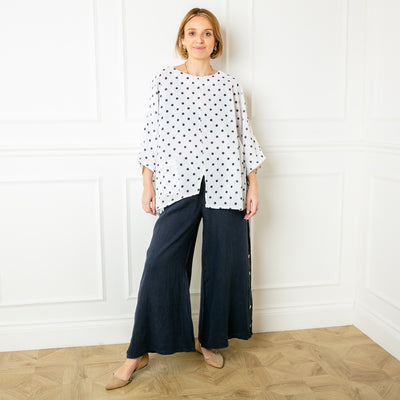 The white and black Polka Dot Linen Blend Top with an asymmetrical hemline and a pocket on one side