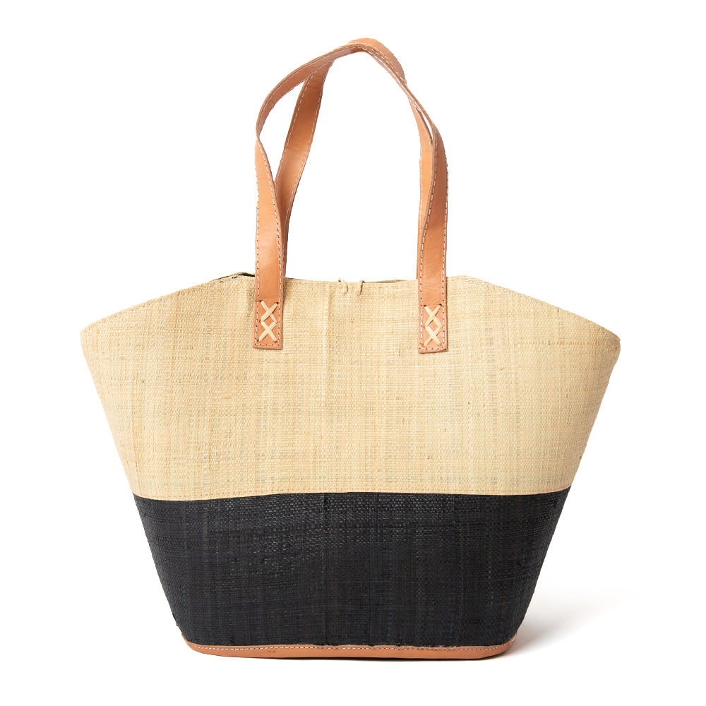 The Raffia Shopping Basket in natural brown and black with leather handles and a cotton inner lining