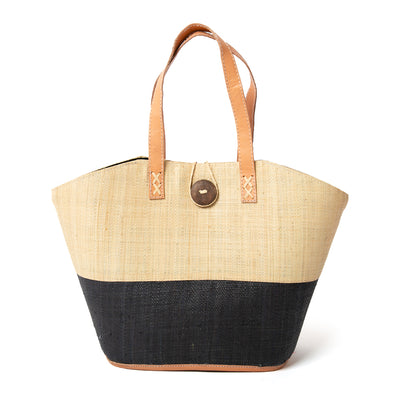 The Raffia Shopping Basket in natural brown and black with a wooden button fastening detail at the top