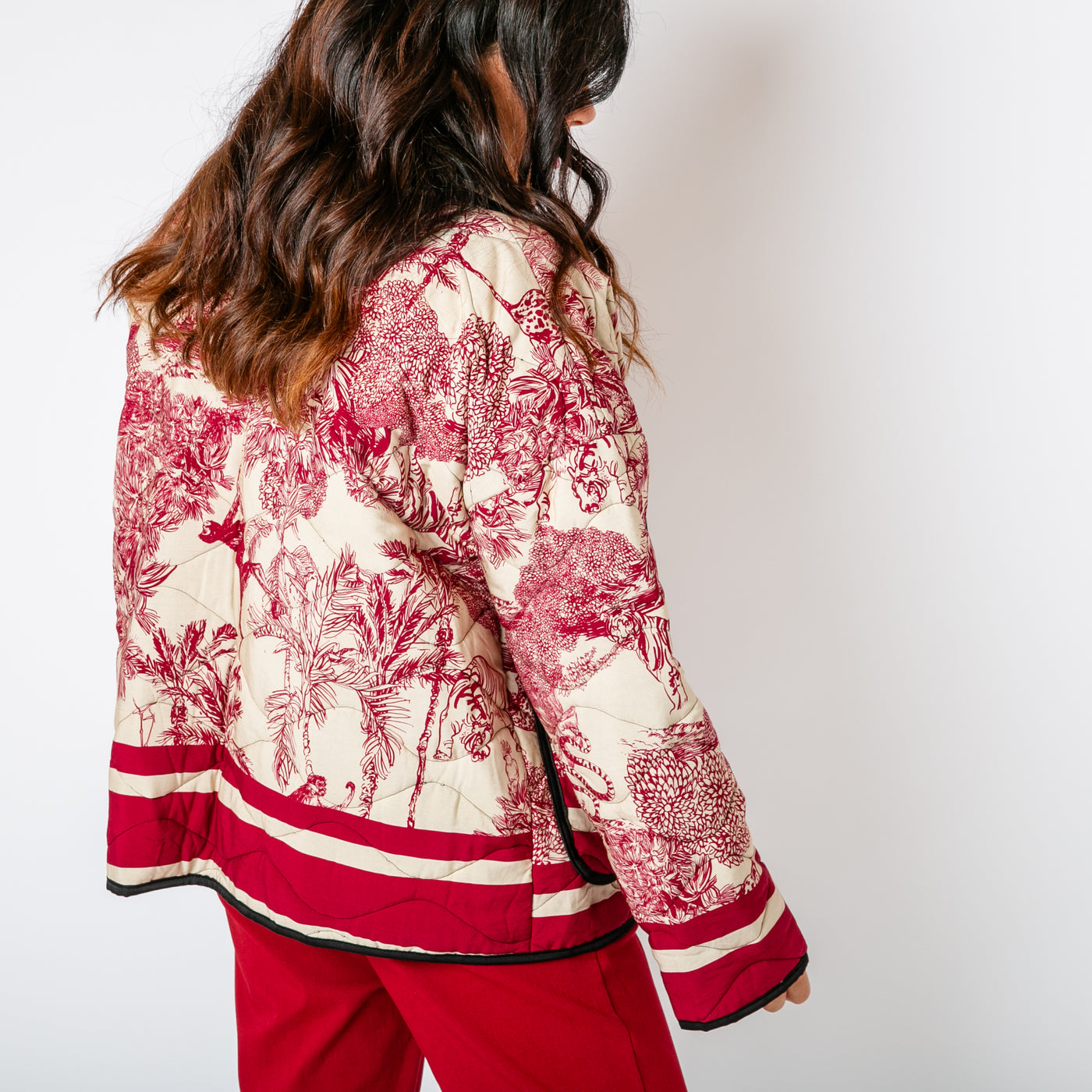 The Berry Red Rainforest Quilted Jacket with pockets on either side of the hips