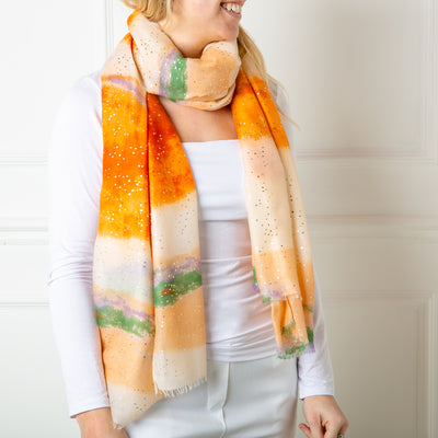 The orange Coral reef Scarf featuring specks spots of gold foil for a bit of extra sparkle