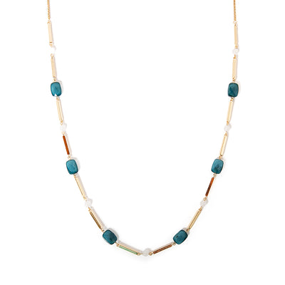The Rhea necklace in gold with blue and white beads dotted along the chain
