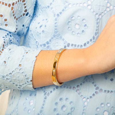 The gold Roxanne Cuff Bracelet with a hinge to open and a magnet clasp fastening for easy wear
