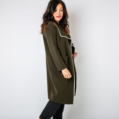 The olive green Scallop Stitch Knitted Coat with contrasting white stitching around the opening and neckline