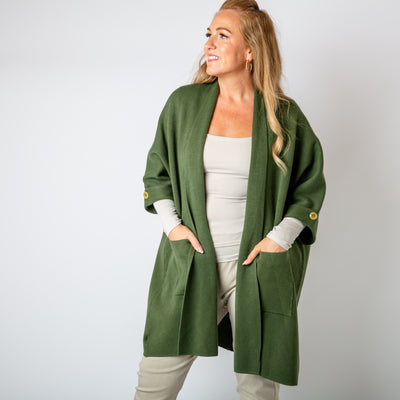 The khaki green Shawl Button Cardigan with pockets on either side of the hip