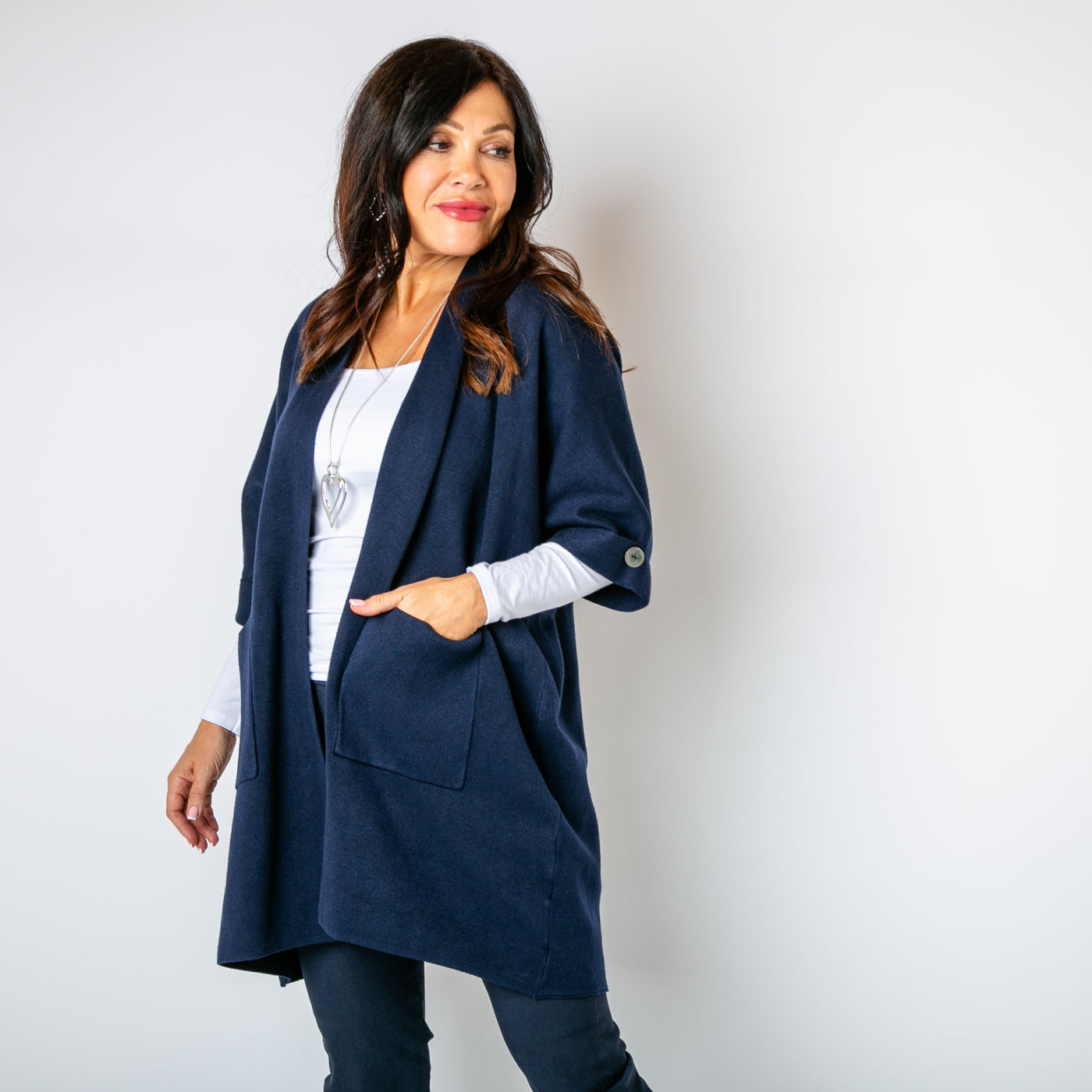 The navy blue Shawl Button Cardigan with pockets on either side of the hip