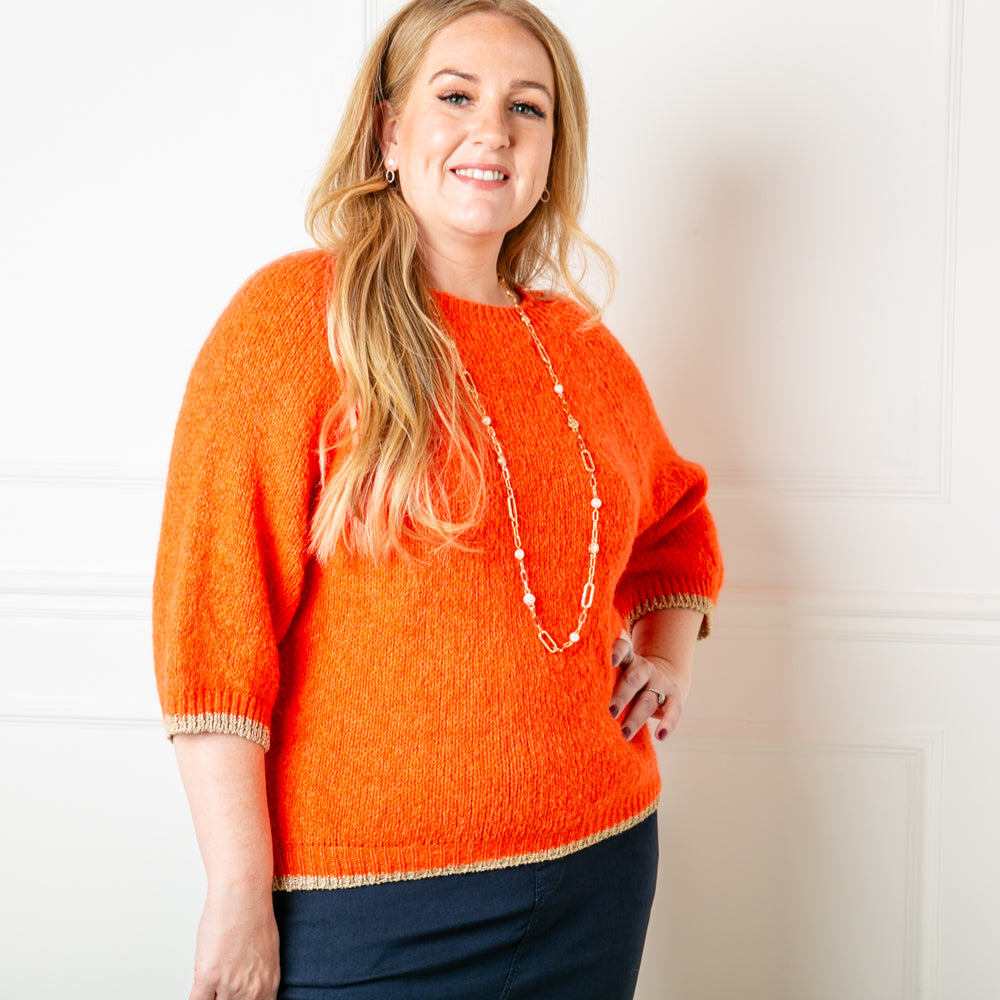 The Shimmer Trim Jumper in orange with a round neck and 3/4 length sleeve