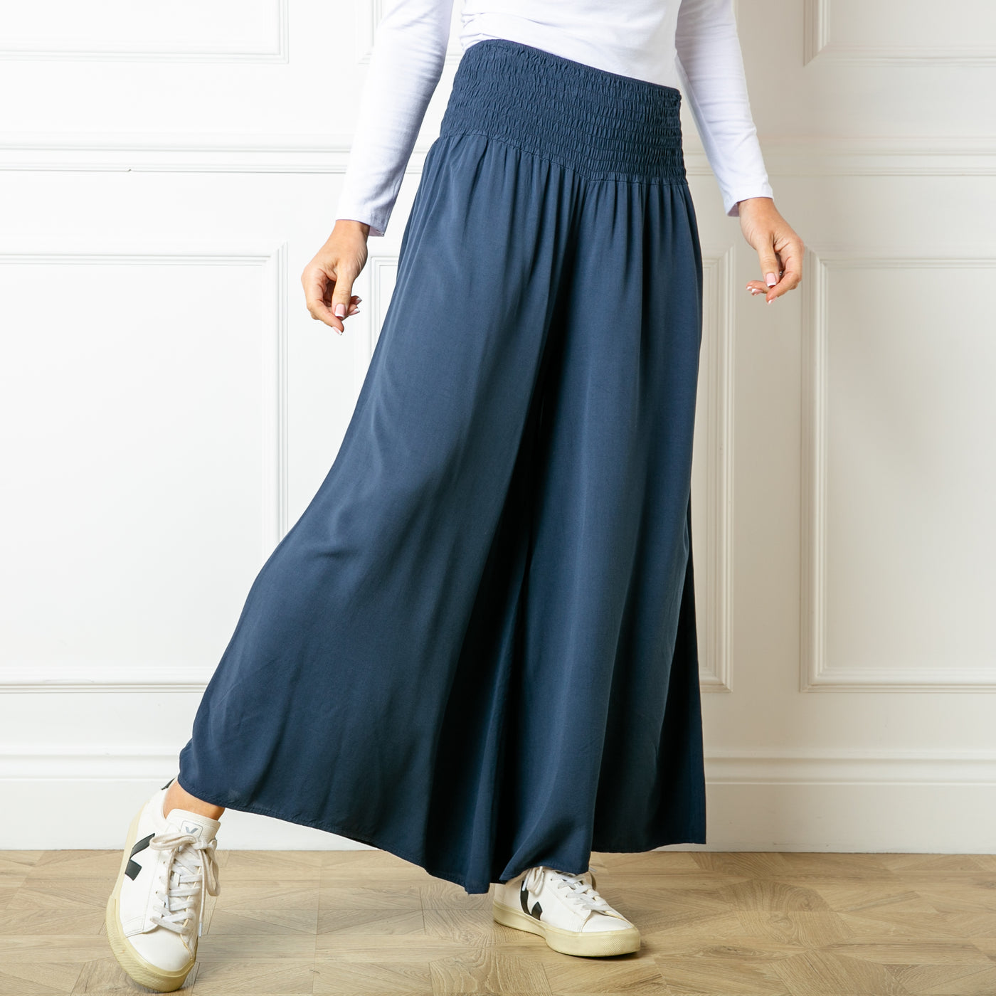 The navy blue Shirred Waist Wide Leg Trousers with a relaxed loose fitting silhouette around the legs