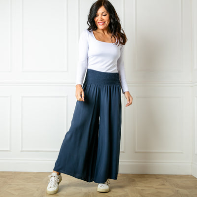 The navy blue Shirred waist wide leg trousers featuring a wide, stretchy elasticated waistband
