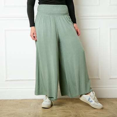 The sage green Shirred Waist Wide Leg Trousers with a relaxed loose fitting silhouette around the legs