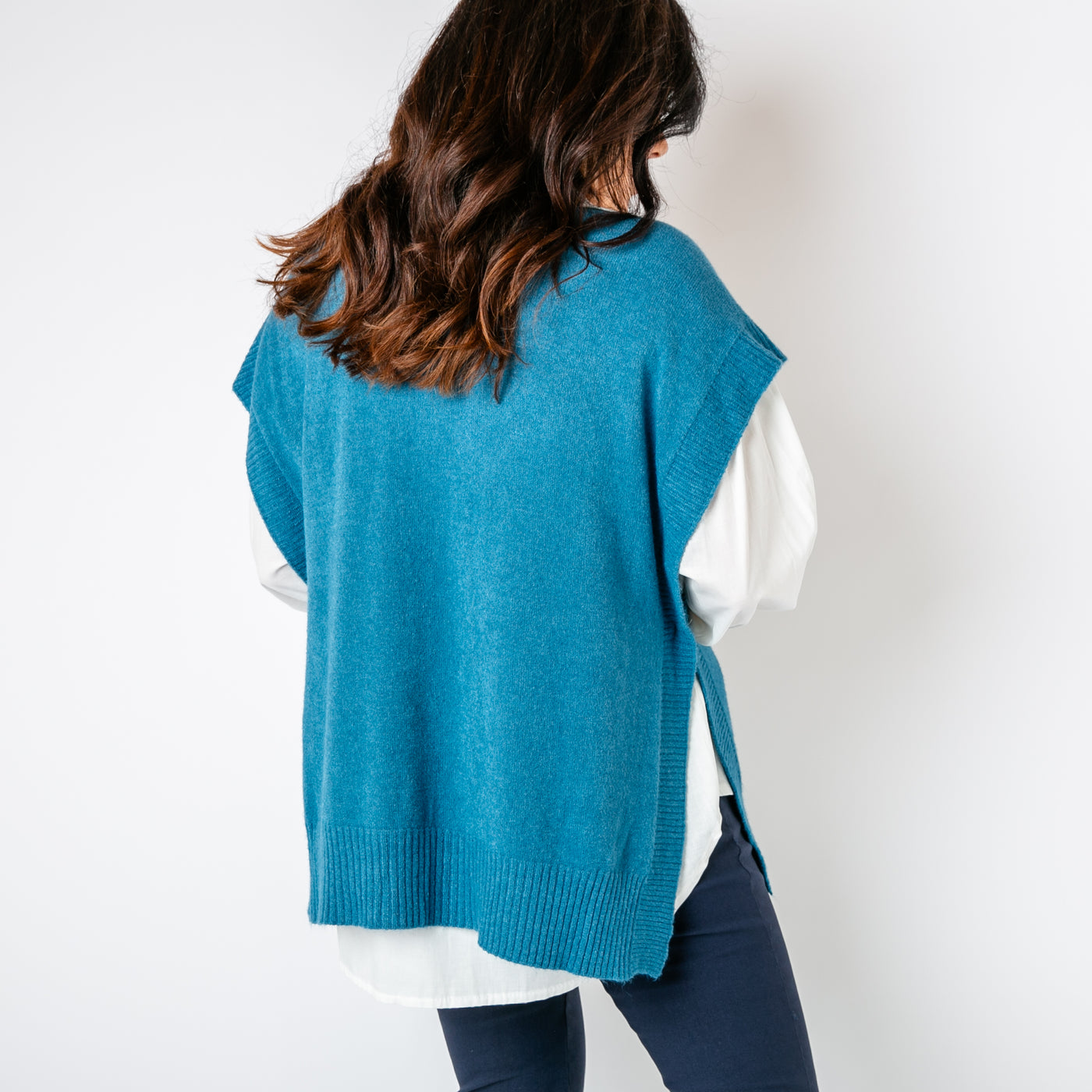 The teal blue Side Button Knitted Vest with ribbed detailing around the sides and on the bottom hem