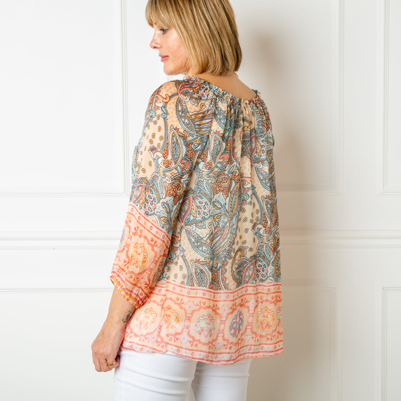 The cream Silk Blend Paisley Top with a round neckline with elastic and gathering around the neckline