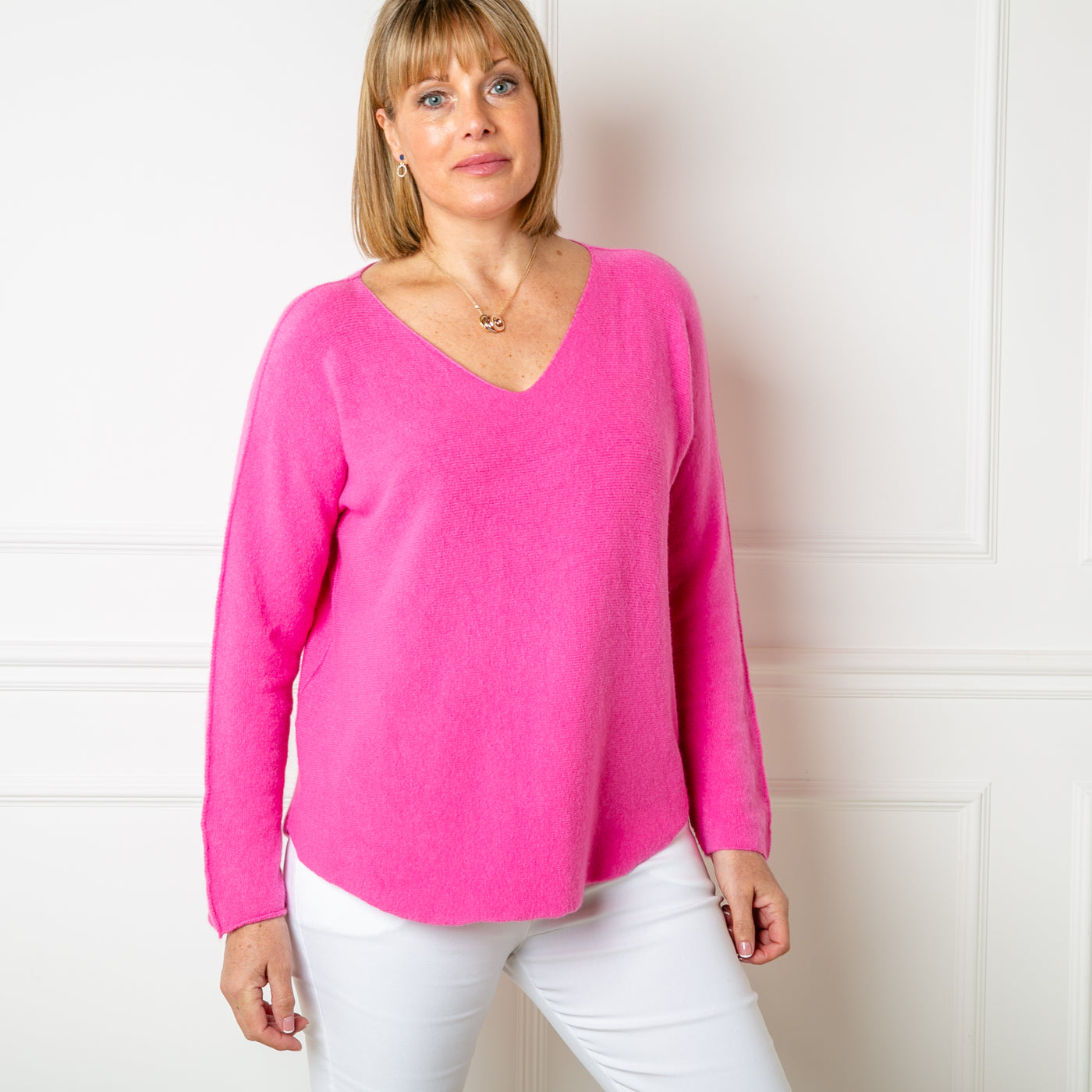 The fuchsia pink Soft V Neck Jumper with long sleeves and statement seam detailing from the shoulder down