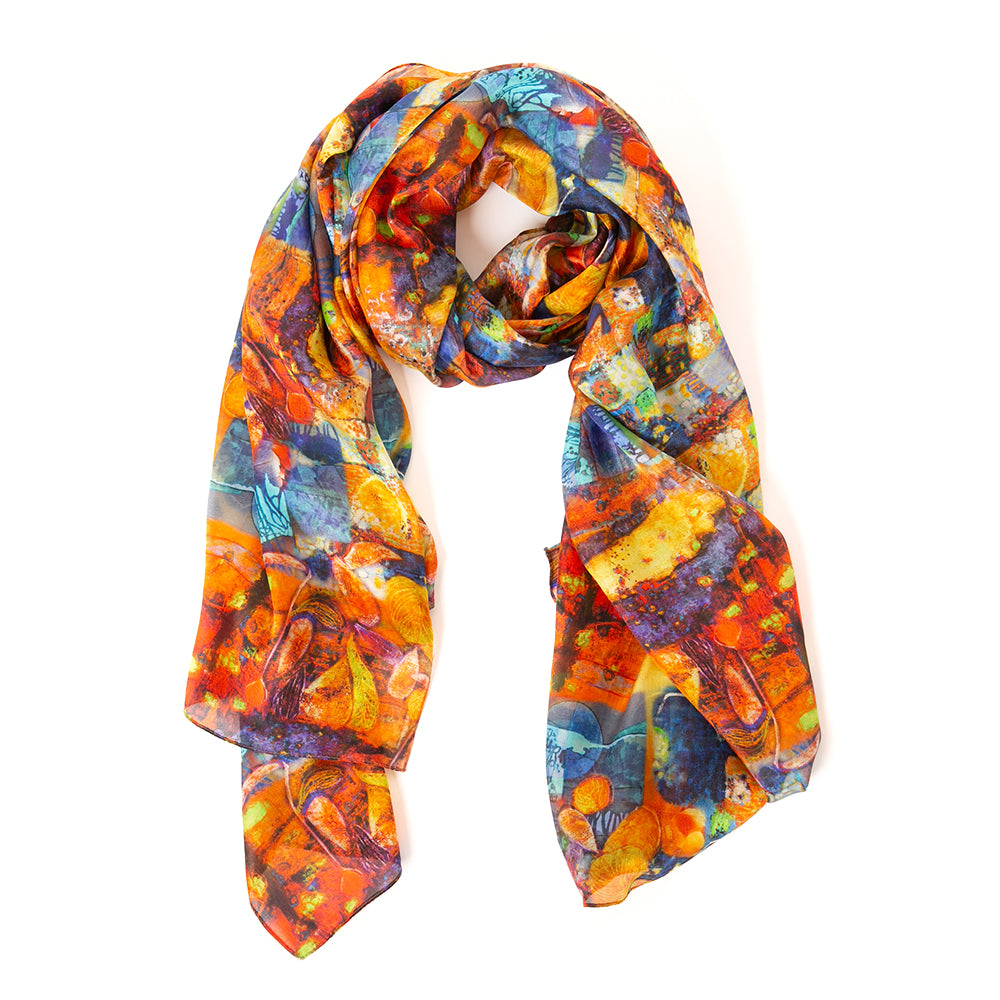The Starfruit Silk Scarf with shades of red orange blue and yellow