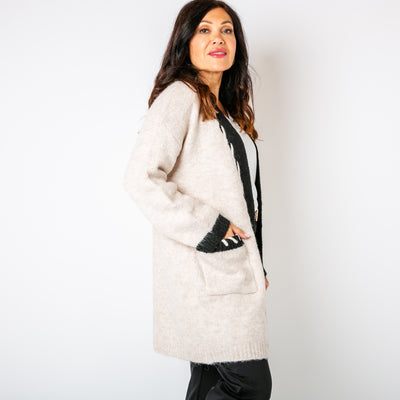 The cream Stitch Edge Cardigan with pockets on either side of the hips