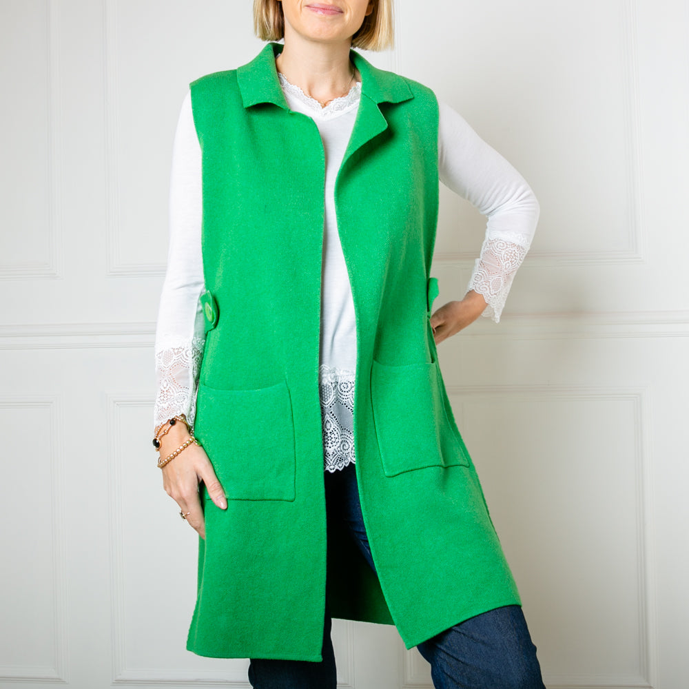 The emerald green Sleeveless Knitted Blazer with an open front and a collar 