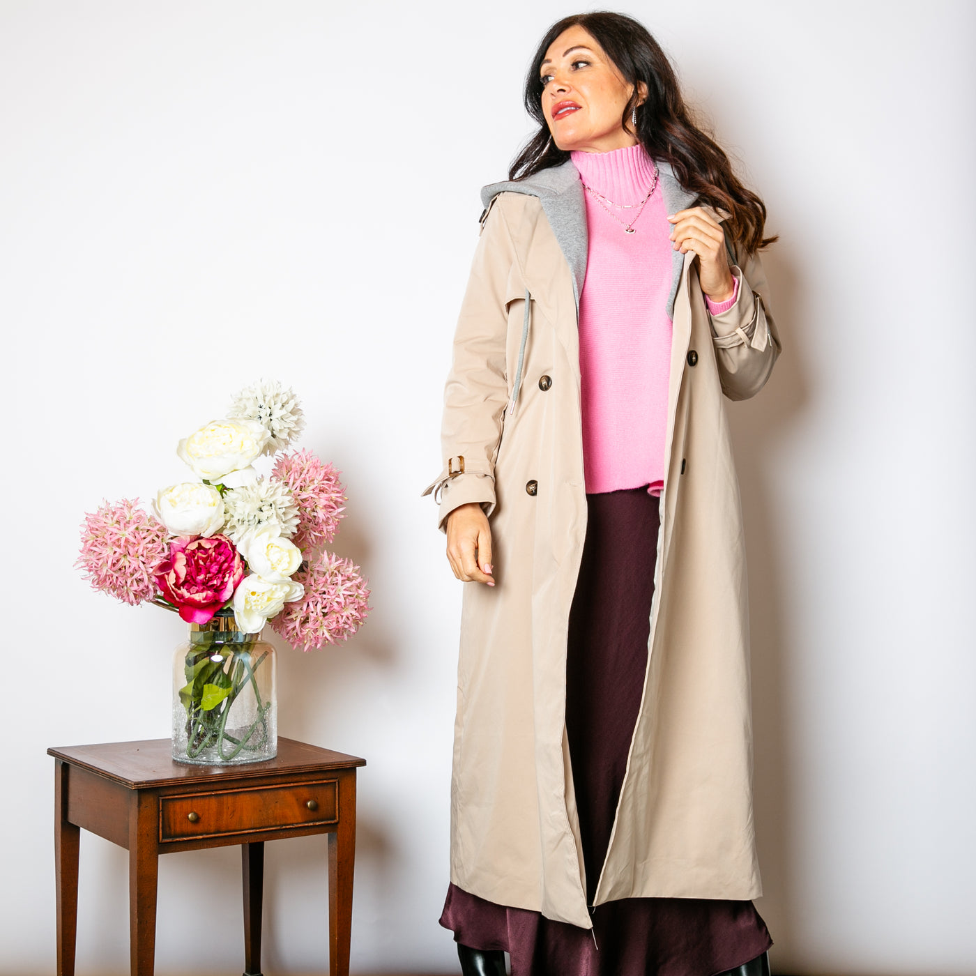 The stone cream Trench Coat With Hood that has long sleeves that have buckles on the cuffs.