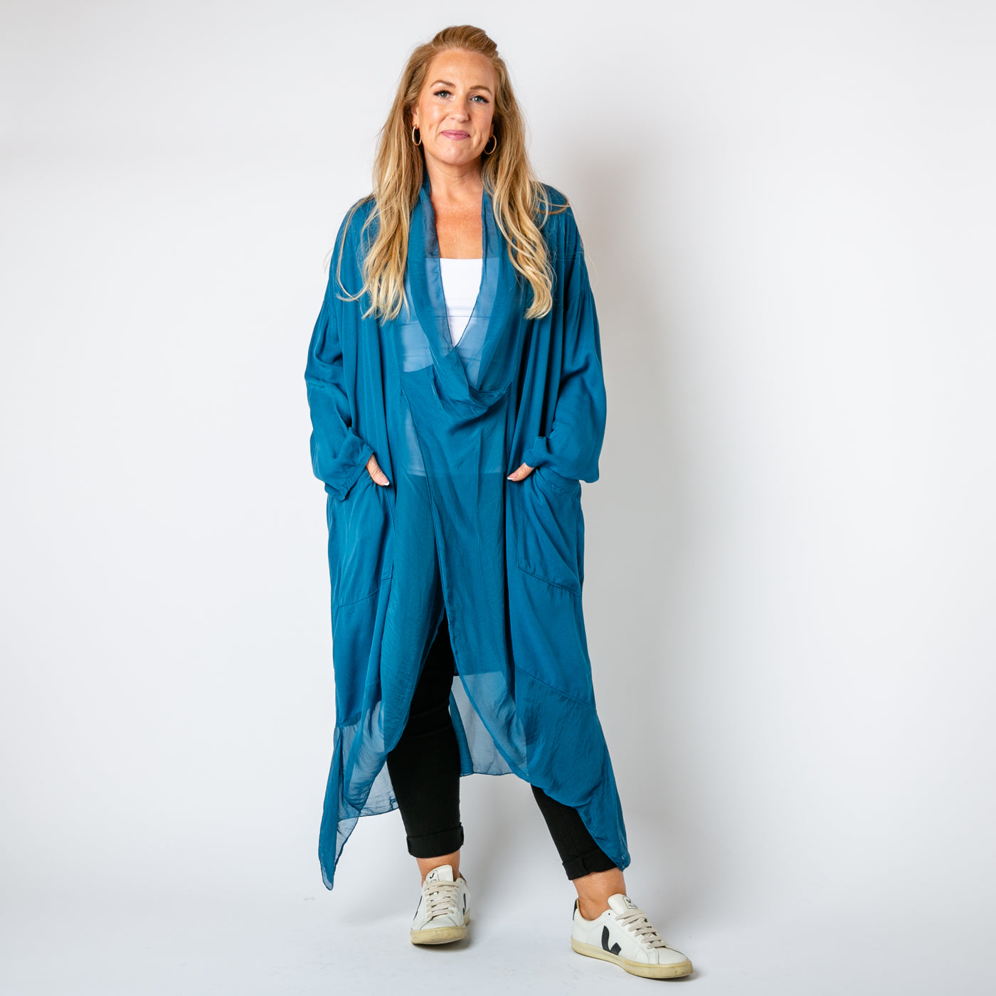 The teal blue Two Pocket Crossover Tunic with long sleeves and a loose fit