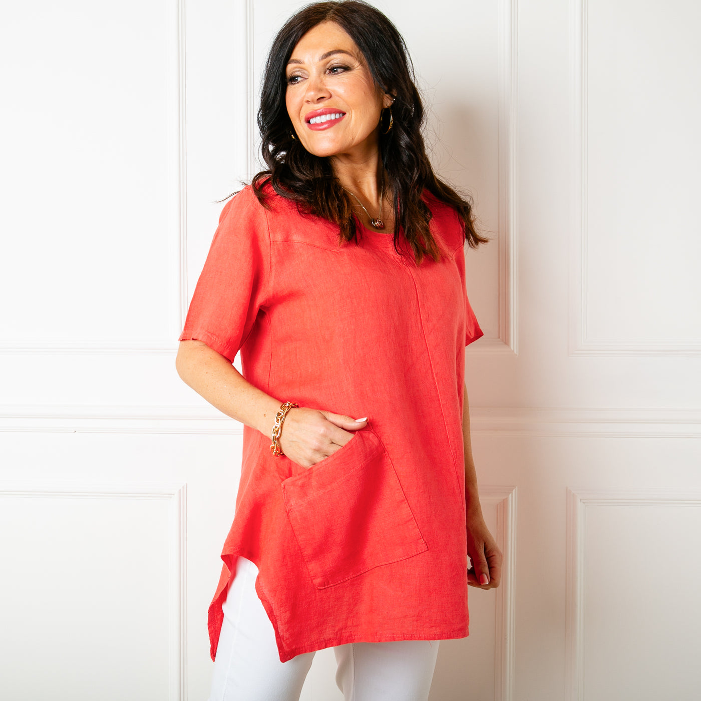 The coral orange red Two Pocket Linen Top with a statement flared hemline