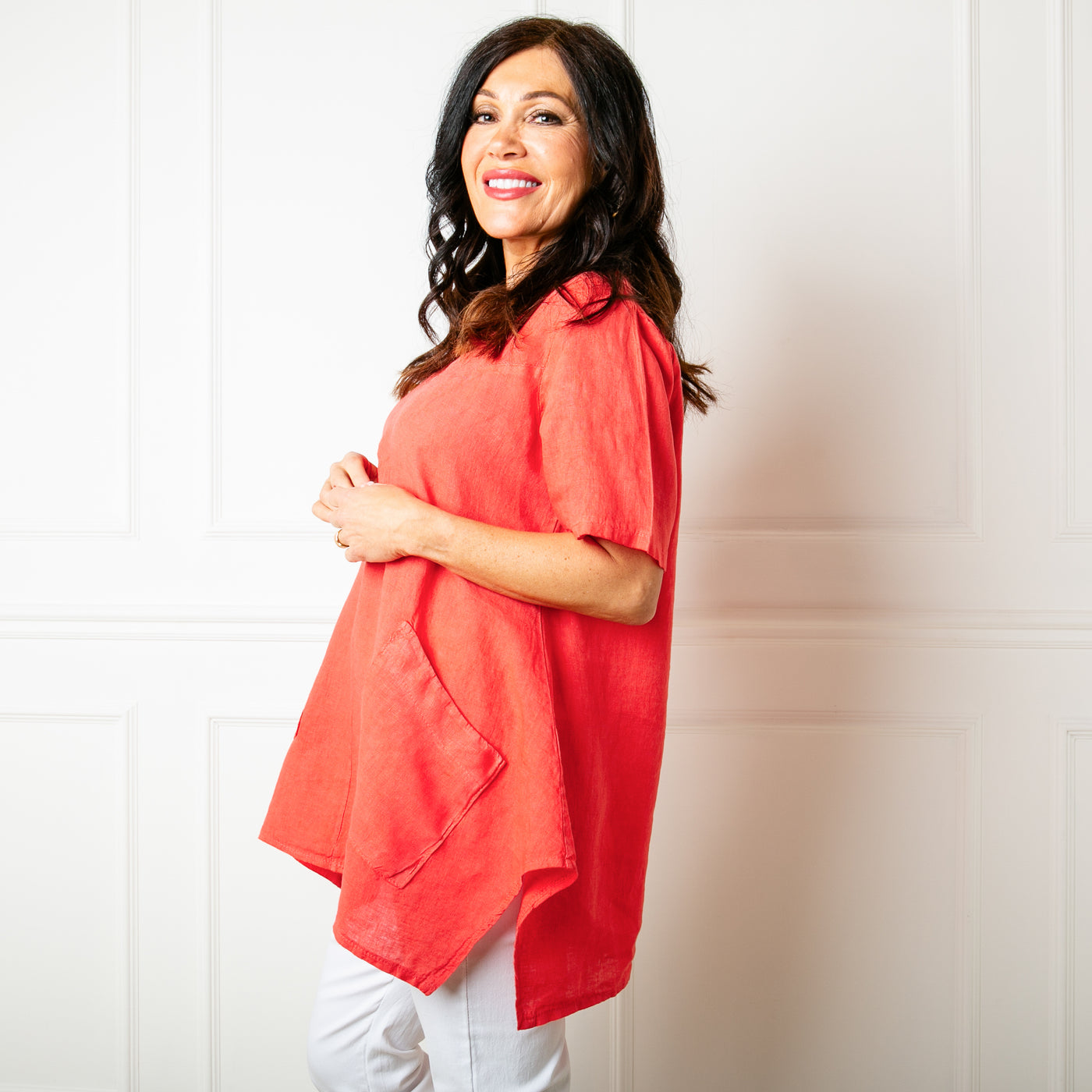 The coral orange red Two Pocket Linen Top with slanted pockets on either side of the waist