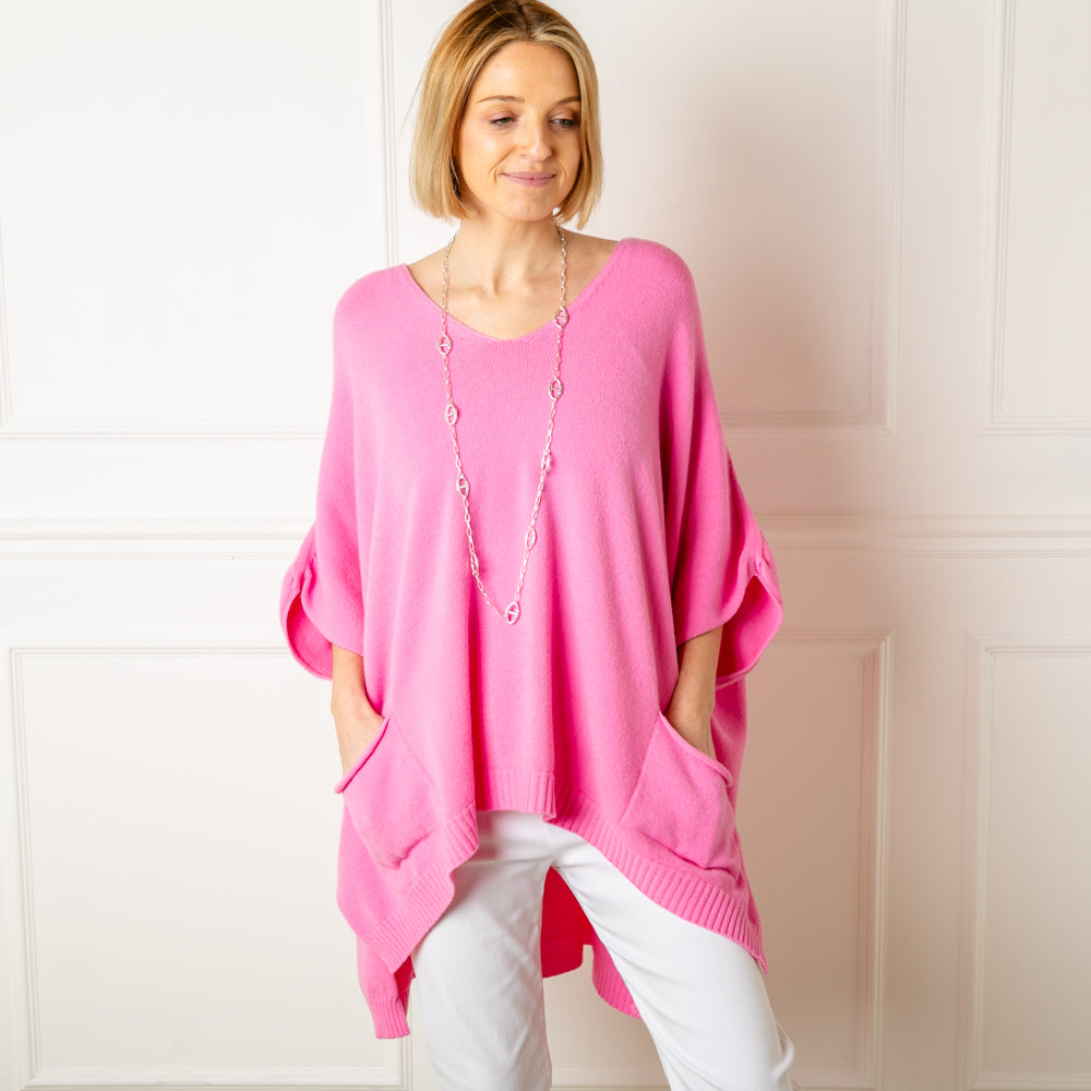 The pink V Neck Pocket Poncho in a relaxed silhouette made from a fine knitted material