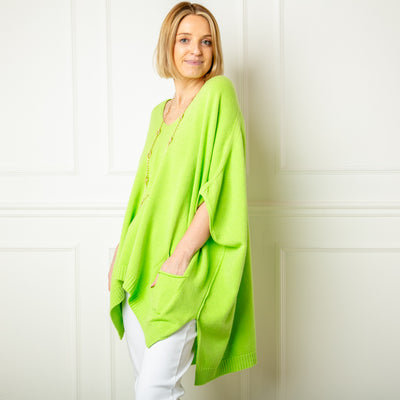 The lime green V Neck Pocket Poncho in a relaxed silhouette made from a fine knitted material