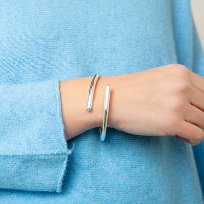 The Verity Twist Bangle in silver made from a chunky plated metal with a hinge fastening for easy wear