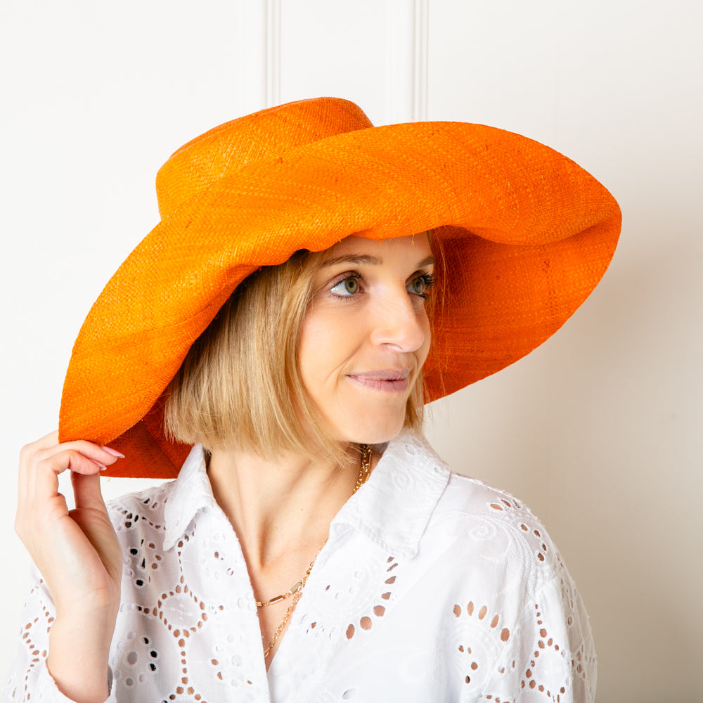 The orange Versailles Sun Hat Which can be styled in lots of different ways with the brim folded up or down