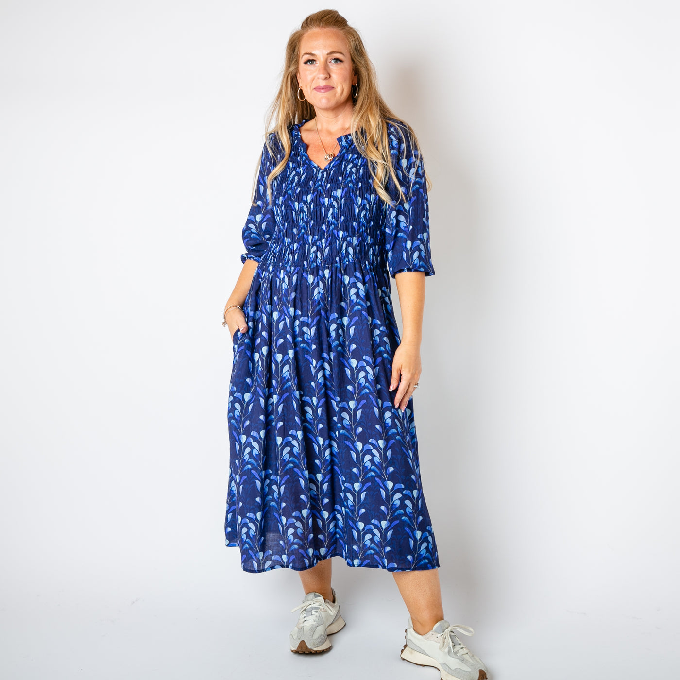 The navy blue Watercolour Leaf Shirred Dress with pockets on either side of the hip