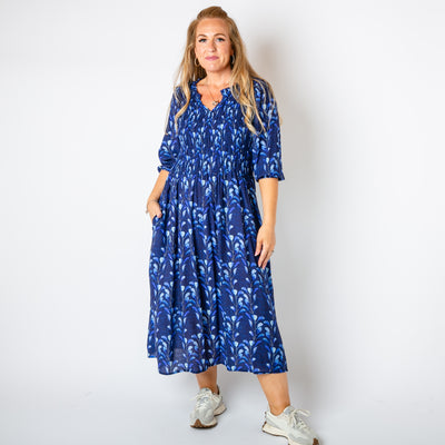 The navy blue Watercolour Leaf Shirred Dress with pockets on either side of the hip