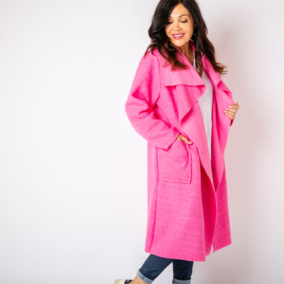 The bright pink Waterfall Roll Sleeve Coat with long sleeves and pockets on either side 